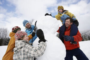 family plays in the snow